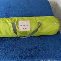 Green carrying case for one person tent with handle and label stating '1 PERSON TENT'