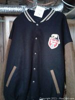 Front view of men's black varsity-style jacket with brown suede sleeves and Canadian Pacific Rail patch on chest.