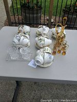 Table arrangement of cup and saucer sets, decanter, glasses, cream and sugar on tray