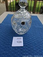Full view of crystal bowl with lid showing ornate cut pattern and finial handle with sticker visible on bowl body