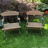 Two vintage outdoor chairs with metal frames and wooden slats for seats and backs, one chair has armrest taped.