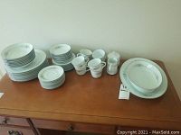 Full set displayed on wooden table showing all dish types and serving pieces.