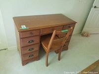 Wooden desk and chair side view showing drawer arrangement and chair design