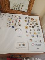 Overview of assorted curling pins laid out on a table with some memorabilia and labels.