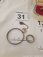 Shows the baby bracelet bangle, 18K gold ring, and vintage baby necklace with pendant all placed together on a white background with auction tag.