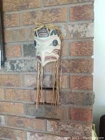 Wood raven mask hanging on brick wall