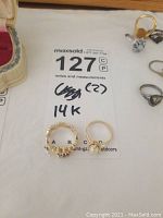 Overview of two 14k gold rings on white surface with lot label
