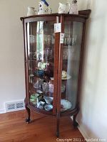 Front view showing curved glass front and claw feet