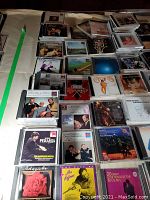 Overview photo showing a large collection of CDs spread out on a table, multiple stacks and rows visible