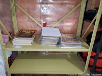 Metal shelving unit with three stacks of comics and a handwritten title list visible