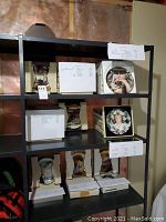 Photo of shelving with various boxed decorated collector plates and paperwork, showing plates from Rockwell series and other designs.
