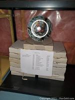 Stacked boxed collector plates with a single displayed plate featuring a red bird surrounded by green leafy border. Included printed list names and years from a series.