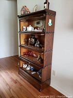 Full front view of four-section barrister's bookcase with display shelves