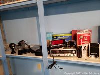 Shelf with vintage audio equipment including audio receivers, Realistic microphone box, and Ion film scanner