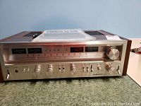 Front left perspective view showing overall unit, analog tuner display, function knob, speaker A/B buttons