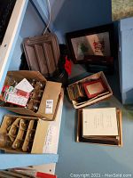 Wide angle photo showing the lot contents including Mason jars in a box, plastic storage container, and various picture frames stacked near the wall.