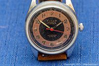 Close-up of watch front showing two-tone dial, Titus Geneve 17 Jewels marking and waterproof Incabloc text