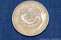 Obverse side of silver Chinese coin showing dragon design and inscriptions from Kwang Tung Province.