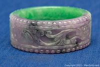 Front angled view of the thick bangle bracelet showing carved details and color tones