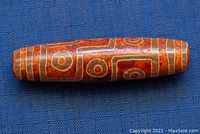 Close-up front view of the elongated agate bead showing circular and linear geometric patterns