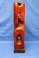 Front view of the mid-century modern carved wooden sculpture showing various carved openings and artistic texture on wood surface.