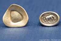 Close-up of the back of the plain triangular-shaped sterling silver ring showing its smooth surface and tarnish.