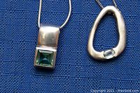 Close-up of the two 925 sterling silver pendants on chains showing details and markings