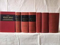 Group photo showing seven volumes of The Canadian Who's Who with red cloth covers and black or gold titles on spines, arranged in a row.