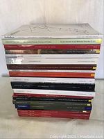 Photo of vertical stack of Sotheby’s and Christie’s catalogues for Latin-American art sales showing spines and titles.