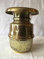 Side view of the heavy brass vase showing hammered texture and slight rust and dents.