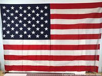 Full view of the large USA flag showing the red and white stripes and blue field with 50 white stars.