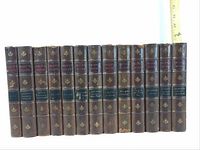 Full set of 13 Ibsen works volumes in brown leather bindings with gilt floral spine decorations, two colored (red, green) spine labels with title text. Set arranged side-by-side for scale and condition view.
