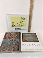 Three Paul Klee art books arranged side by side with dust jackets visible and a ruler for scale.