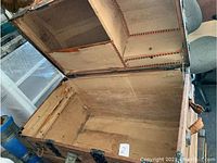 Open dome top trunk showing interior compartments lining and shelving, visible wear and tear inside lid.