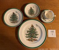 Set of Spode Christmas Tree dinnerware showing dinner plate, bowl, tea cup, and saucer with green rim and Christmas tree decoration