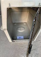 Interior view of the beige plastic dog kennel showing bottom and sides in good condition