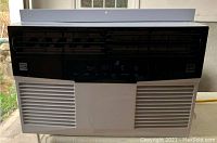 Window air conditioner front view, showing vent grilles and control panel