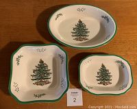 Top view of three Spode Christmas Tree serving dishes on wooden surface showing design and shape differences.