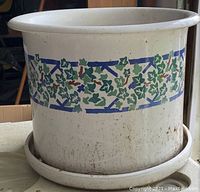 Single image showing large off-white ceramic pot with decorative ivy pattern, set on matching saucer