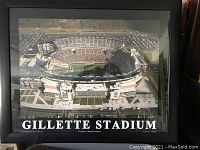 Photo of framed print showing aerial view of Gillette Stadium with stadium name and location text.