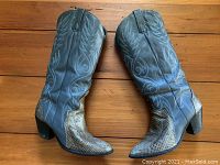 Pair of snakeskin cowboy boots, size 8, shown side by side upright on wooden floor, displaying detailed stitch design and texture.