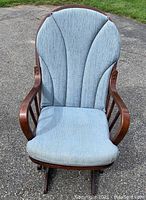 Front view of Dutalier glider chair with blue cushion showing faded fabric and wooden arms