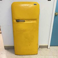 Front view of yellow vintage Westinghouse refrigerator door showing handle and overall condition