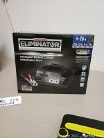 Box of Motomaster Eliminator Intelligent Battery Charger with Engine Start, showing front with product image and key features.