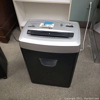 Front view of Fellowes DM12Ct paper shredder showing black bin and silver control panel