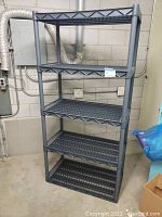 Full view of the 5 tier grey plastic shelf unit, showing all shelves and structure.