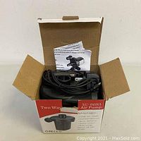 Open box showing electric air pump with cord and attachments inside, includes instruction sheet.