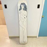 Full view of vintage GNU snowboard with pin up girl graphic showing entire board length and shape.