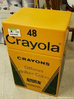 Full view of yellow and green Crayola 48 crayon box-shaped storage container showing 'Crayola 48 Crayons Different Brilliant Colors' text and Binney & Smith logo.