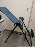 Side-angle view showing full inversion table profile, steel frame and padded bed